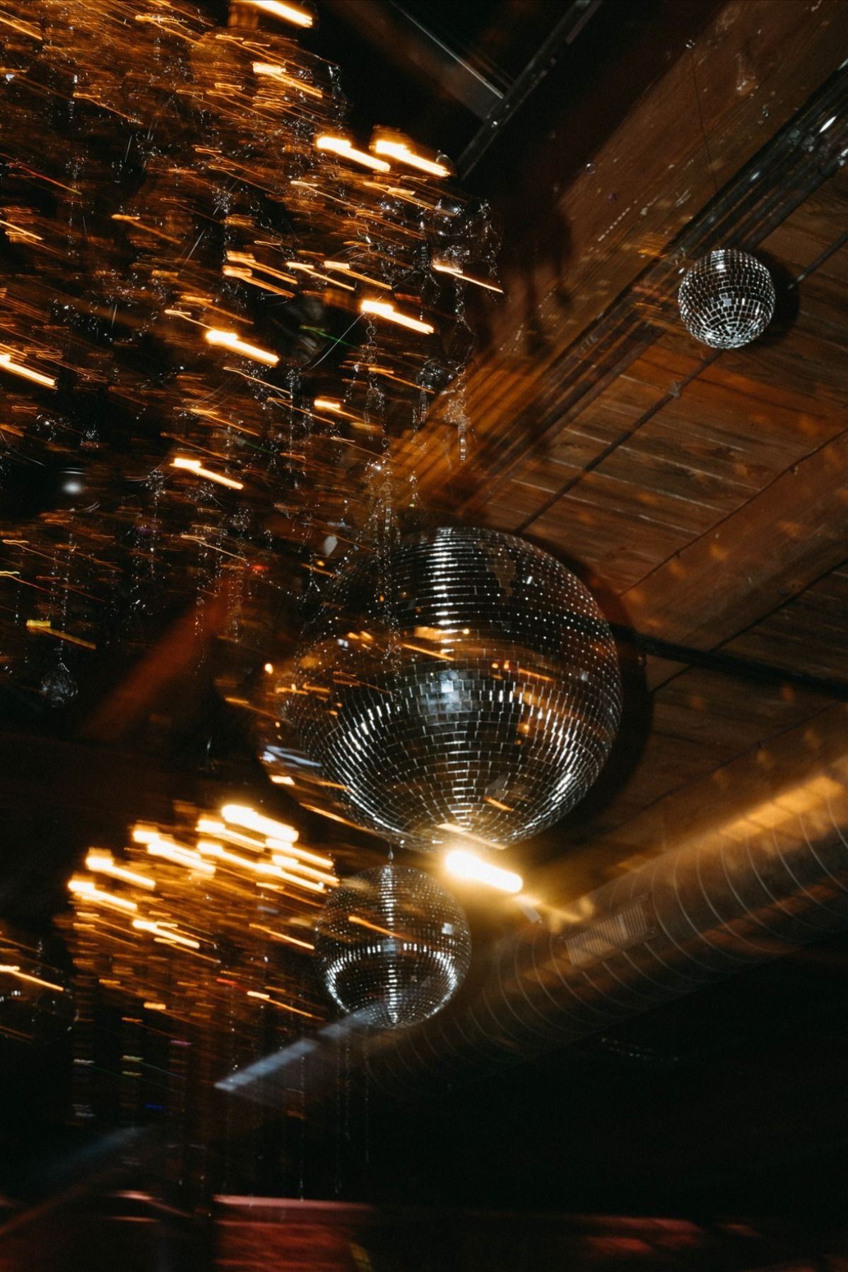 Des boules à facettes au plafond d'un bar, dans une lumière dorée